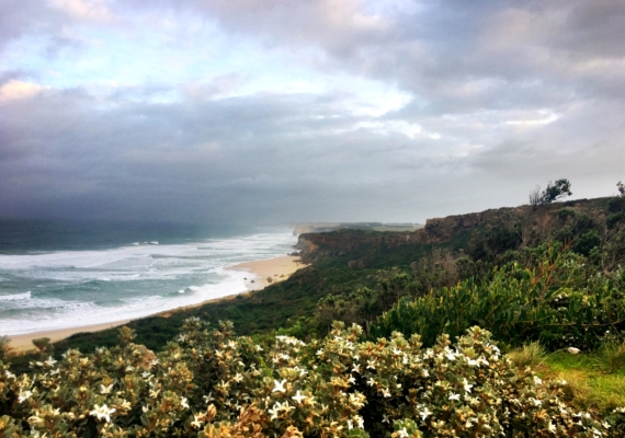 Panoramic view of the coastline , ocean to the left, moody clouds and rock stacks in the disdance