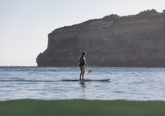 Female on a stand up paddle board in Port Campbell Bay